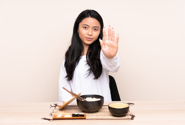 Ragazza asiatica dell'adolescente che mangia alimento asiatico