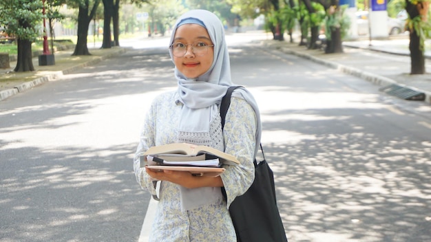 Ragazza asiatica dell'hijab che sta studiando all'università