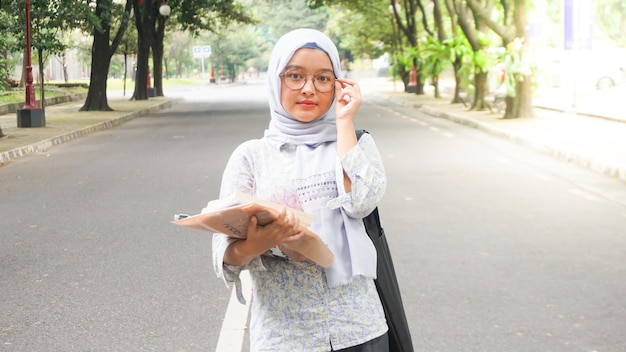 Ragazza asiatica dell'hijab che sta studiando all'università