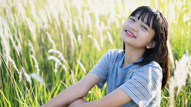 Ragazza asiatica felice che si siede alla bella vista del paesaggio, ragazza teenager.