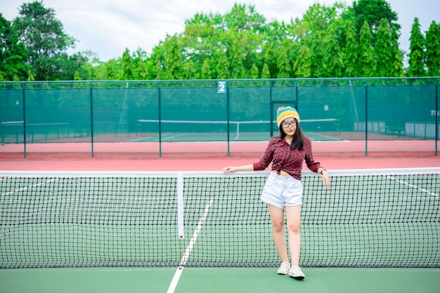 Ragazza asiatica hipster posa per scattare una foto Ritratto di moda donna graziosa al tennis courtlifestyle della moderna ragazza tailandese adolescente