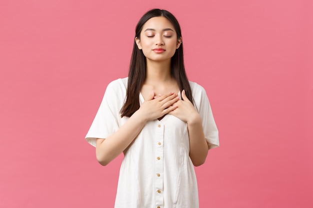 Ragazza asiatica in un vestito bianco in posa