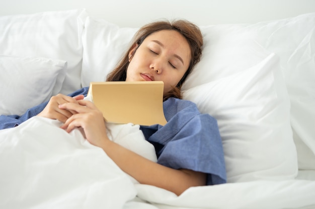 Ragazza asiatica Leggere i libri durante il sonno.