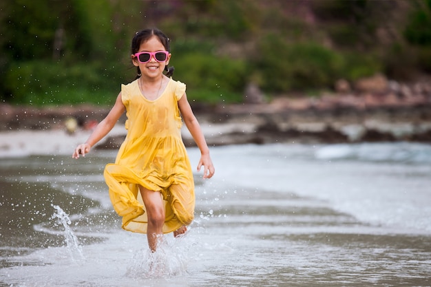 Ragazza asiatica sveglia del piccolo bambino divertendosi da giocare ed eseguire