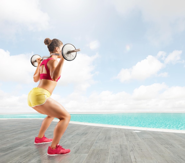 ragazza atletica si allena in palestra con un bilanciere