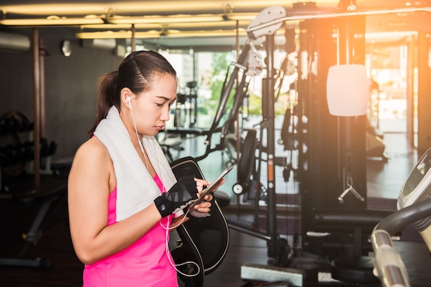 Ragazza attiva, ragazza di forma fisica che utilizza smartphone nella palestra