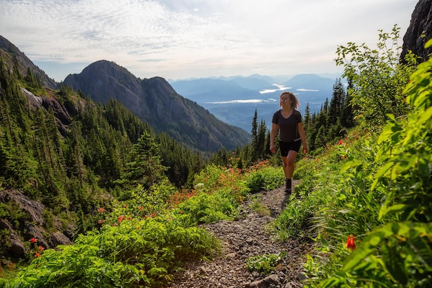 Ragazza avventurosa che fa un'escursione il sentiero nel paesaggio montano canadese