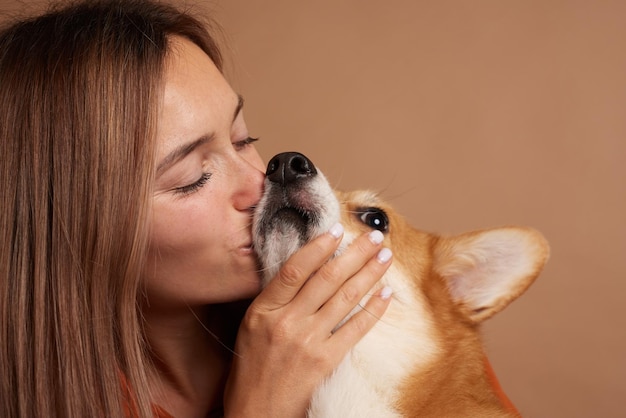 Ragazza bacia il naso di un cane Corgi gallese primo piano amore per gli animali concetto