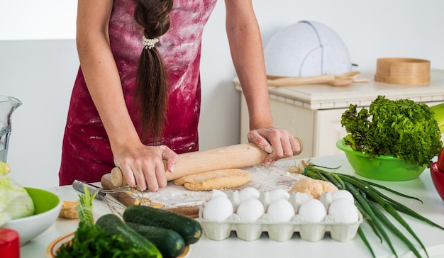 Ragazza bambino in grembiule da cuoco e cappello che cucina cucina