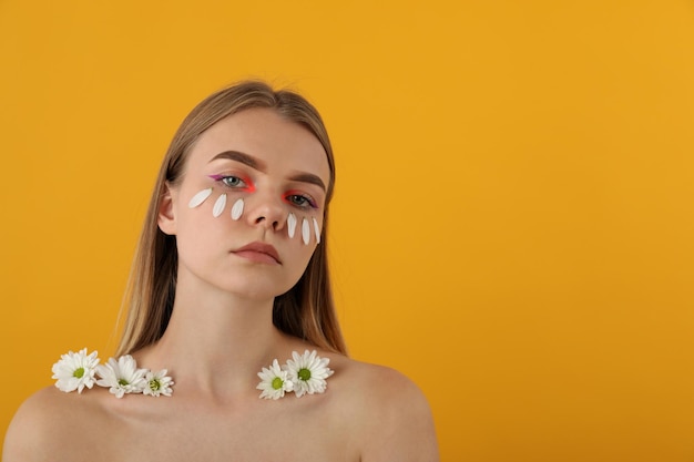 Ragazza bellissima modella con fiori su sfondo giallo