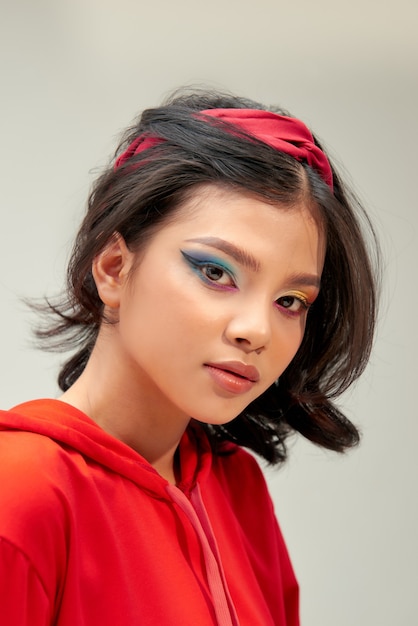 Ragazza bellissima modella con trucco dai colori vivaci e smalto per unghie