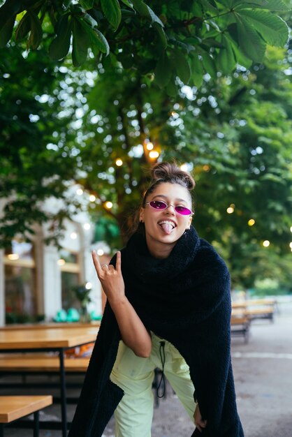 Ragazza bianca affascinante che scherza nel caffè all'aperto