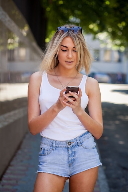 Ragazza bionda che ascolta la musica sul suo smartphone