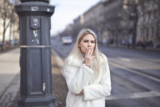 Ragazza bionda che fuma in inverno