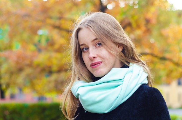 ragazza bionda con le lentiggini su un parco di autunno