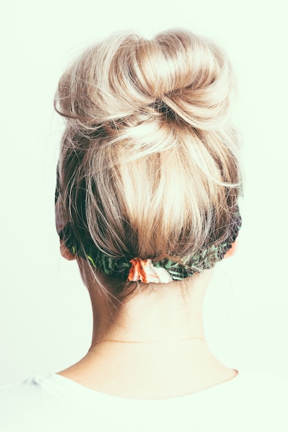 Ragazza bionda con una ciocca di capelli sulla testa vista posteriore