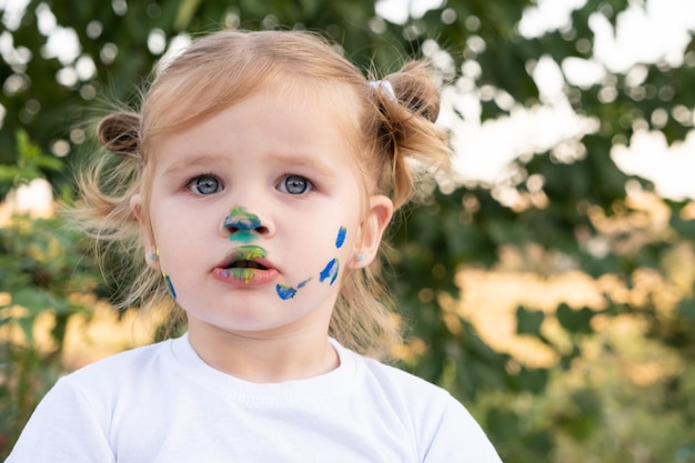 Ragazza bionda del bambino che dipinge con le dita