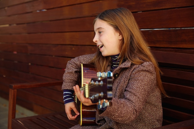 ragazza bionda del bambino che gioca chitarra