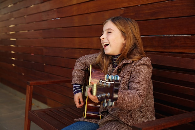 ragazza bionda del bambino che gioca chitarra