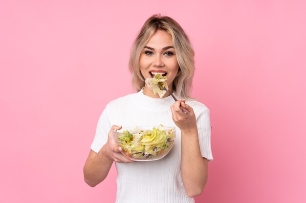 Ragazza bionda dell'adolescente che tiene un'insalata