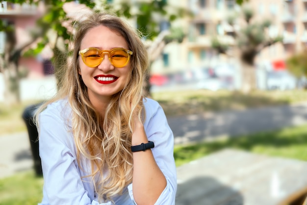 Ragazza bionda in occhiali da sole gialli