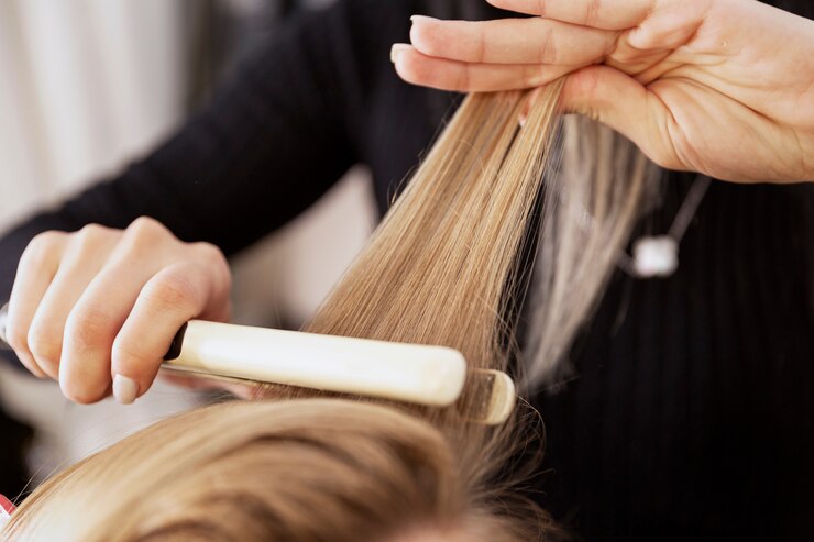 Ragazza bionda in un salone di bellezza che fa un'acconciatura. Avvicinamento.
