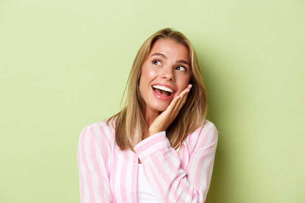 Ragazza bionda in un vestito rosa in posa