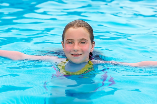 Ragazza bionda nuoto in piscina con le guance rosse