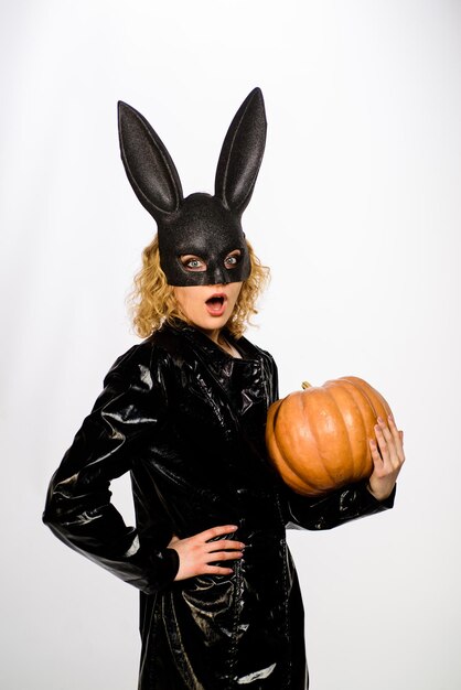 Ragazza bionda sexy in maschera di coniglio nero con zucca modello femminile sexy in coniglietto di pasqua coniglio nero