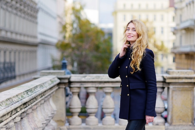 Ragazza bionda sorridente felice che posa sulle vie di Vienna