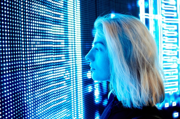 Ragazza bionda su uno sfondo di luci al neon, sfondo futuristico