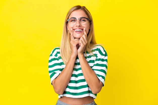 Ragazza bionda uruguaiana isolata su sfondo giallo sorridente con un'espressione felice e piacevole