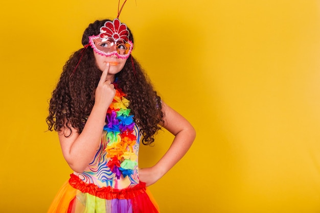 Ragazza brasiliana caucasica vestita per carnevale dito sul mento dubbio incertezza