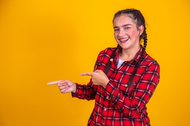 Ragazza brasiliana che indossa abiti tipici per Festa Junina indicando il lato libero per il testo