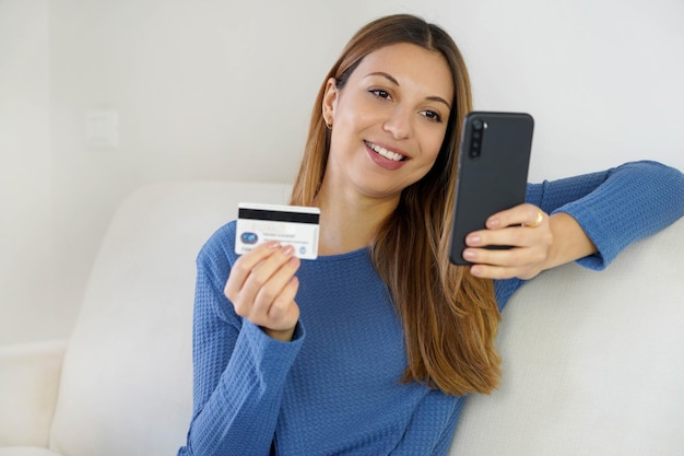 Ragazza brasiliana che utilizza carta di credito e smartphone per pagare gli acquisti online