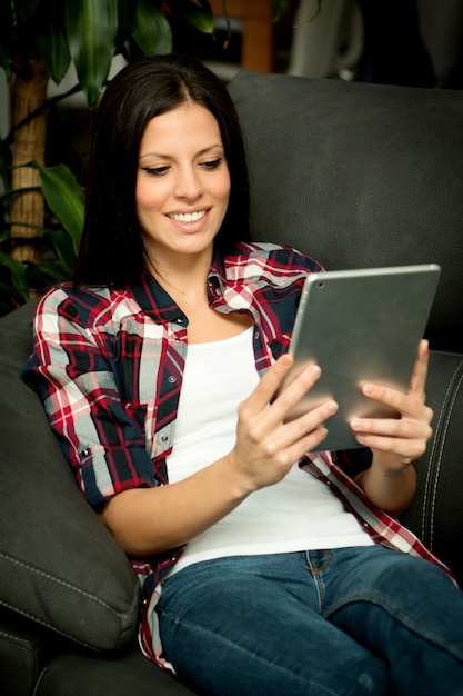 Ragazza bruna con un tablet a casa