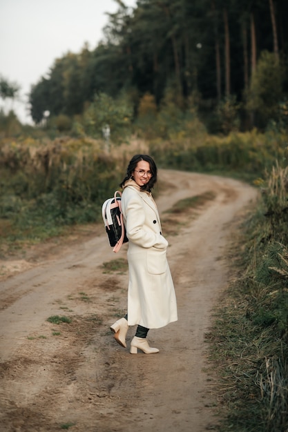 ragazza bruna con zaino sul sentiero nel bosco