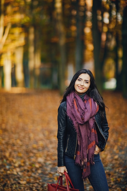 ragazza bruna rilassante al parco durante l&#39;autunno