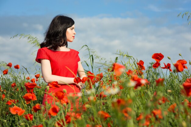 Ragazza cammina in un campo di papaveri