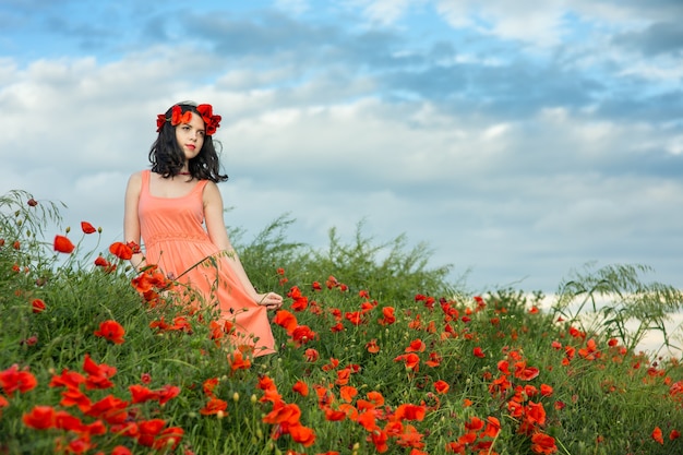 Ragazza cammina in un campo di papaveri