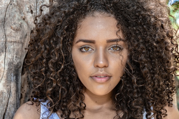 Ragazza carina afroamericana con i capelli ricci nel parco.