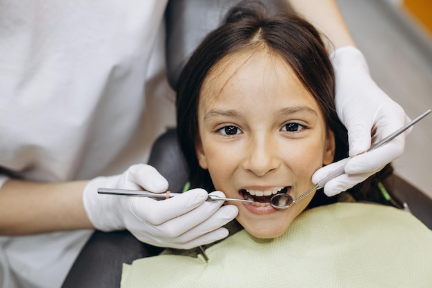 Ragazza carina alla poltrona di odontoiatria che fa il controllo