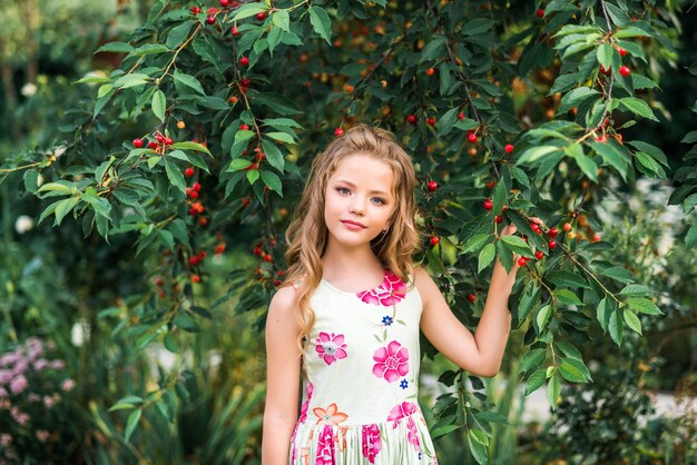 Ragazza carina cammina nel giardino estivo