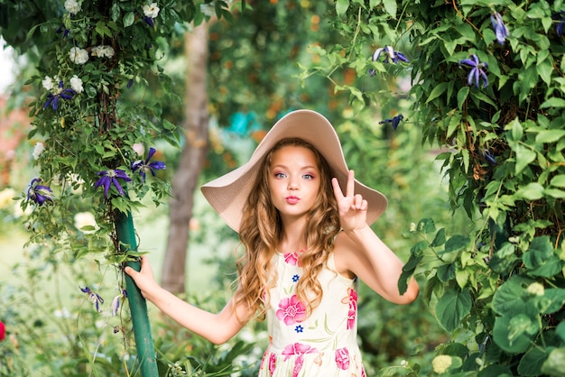 Ragazza carina cammina nel giardino estivo