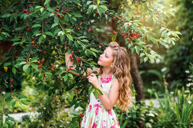 Ragazza carina cammina nel giardino estivo