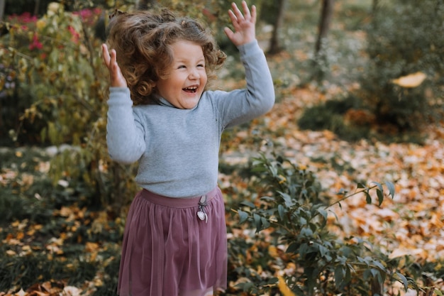 ragazza carina capelli ricci che getta foglie nel parco in autunno carta banner autunno assistenza sanitaria