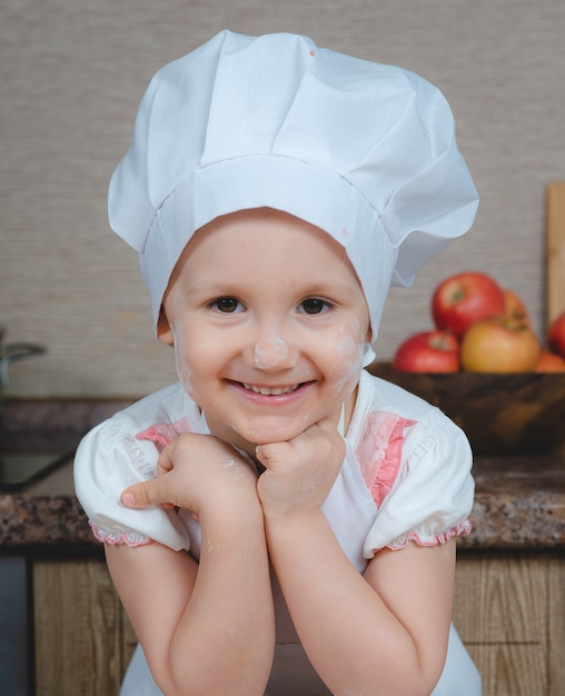 Ragazza carina che cucina in cucina