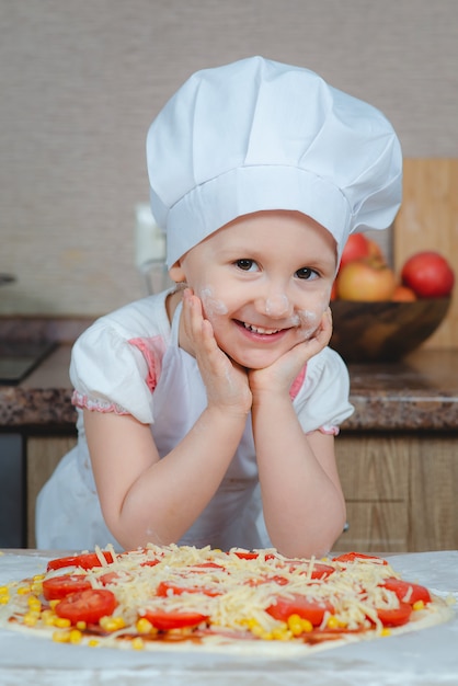 Ragazza carina che cucina in cucina