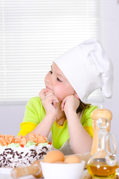 Ragazza carina che cuoce la torta in cucina