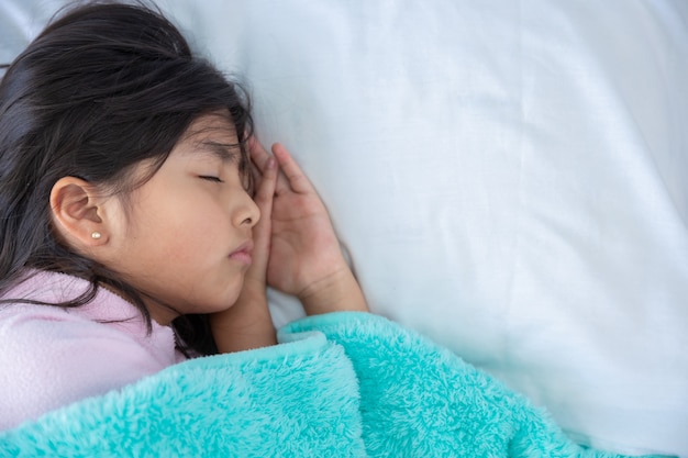 Ragazza carina che dorme nel letto